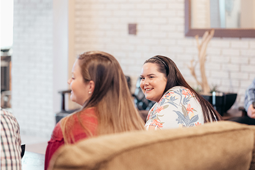 Teenagers laughing together on a couch at Oasis Students